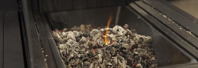 Glut und Asche in noch lodernem Kamin