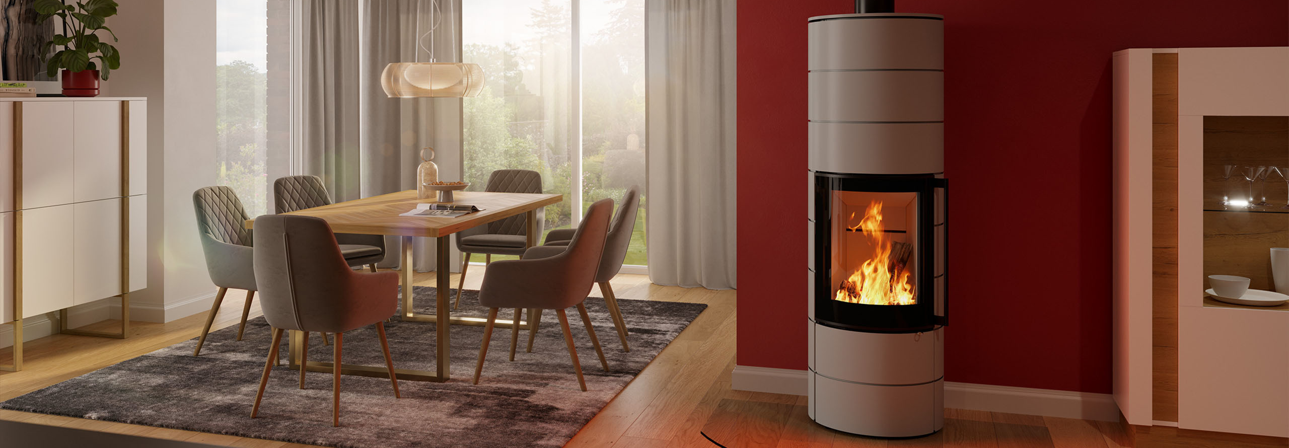 Ein Kaminofen steht in einem Wohnzimmer vor einer rot gestrichenen Wand neben dem Essbereich.