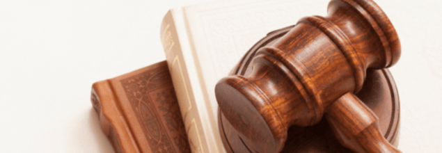 Bild eines Richterhammers, der auf zwei Büchern liegt.
