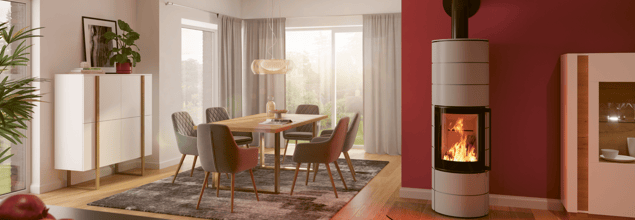 Der Ambiente a4 H2O Kaminofen steht in einem hellen und modernen Esszimmer neben einem Tisch.