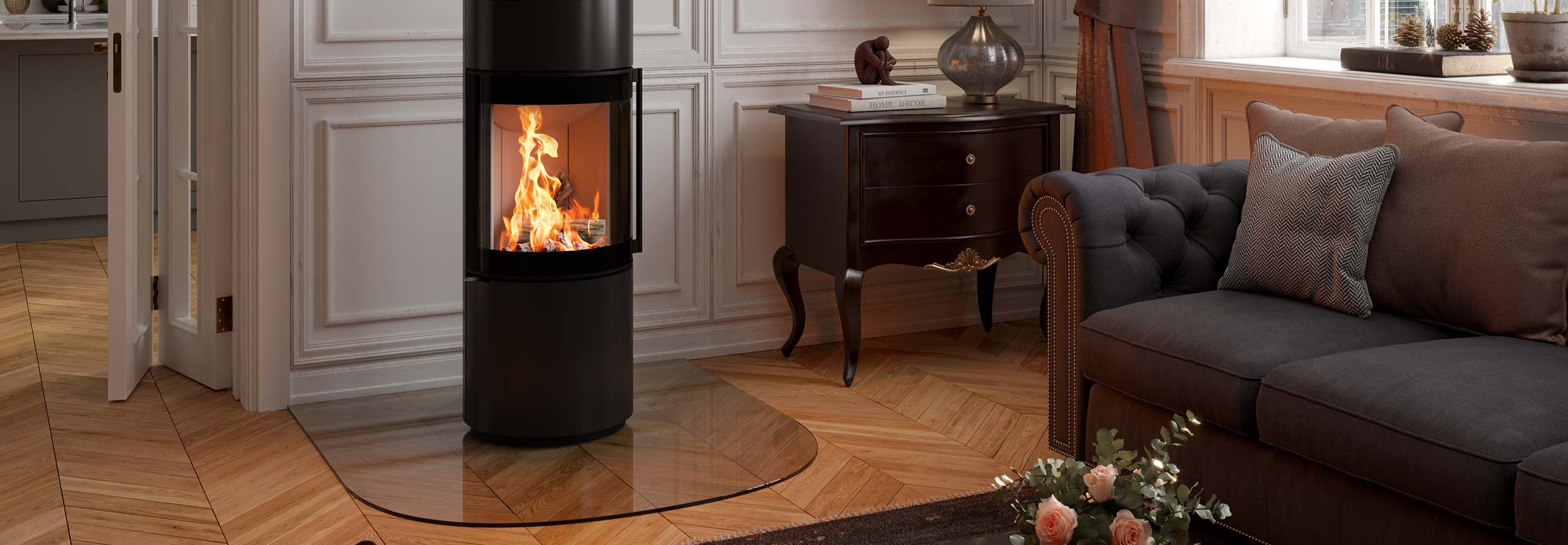 Ein schwarzer Kaminofen steht vor einer weißen Wand in einem klassisch eingerichteten Wohnzimmer.